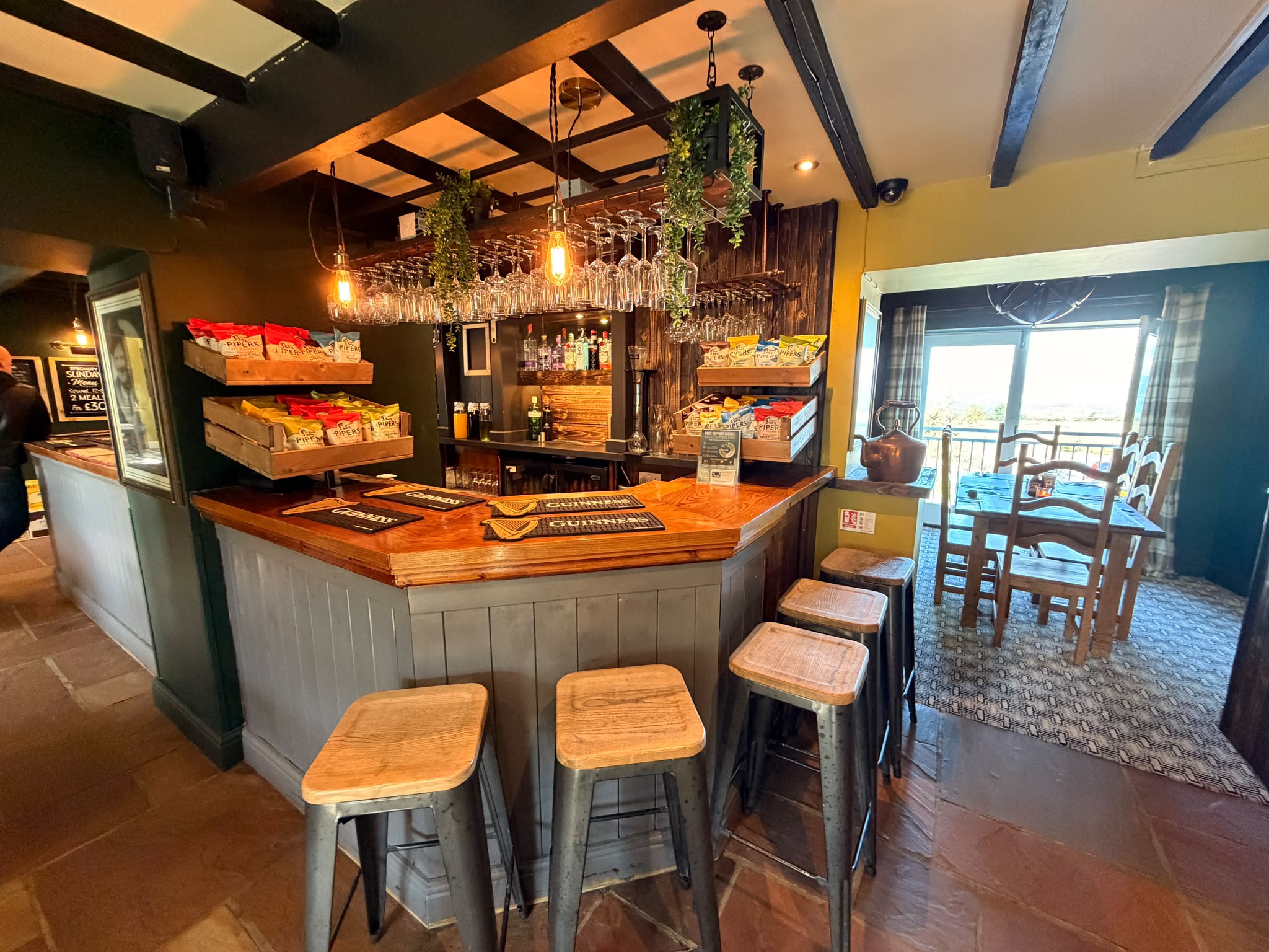 The bar at The Chevin Inn with stools and warm lighting